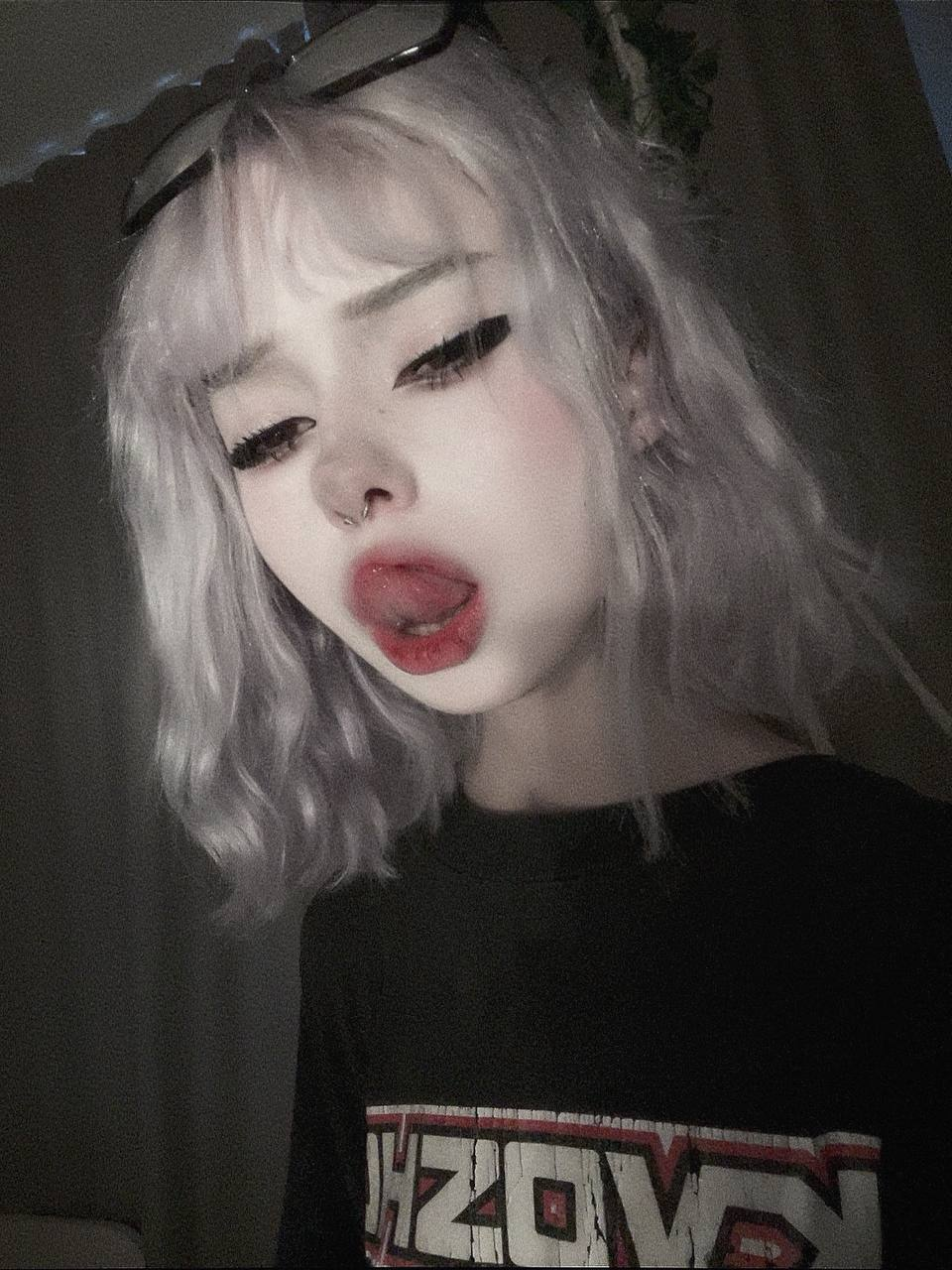 par4doxy, paradoxy, 1girl, female only, white female, looking at viewer, medium hair, caucasian female, piercing, makeup, selfie, pale-skinned female, fringe, bangs, non-nude, nose piercing, black clothes, eyeliner, tongue out, glasses, tongue, wavy hair, ear piercing, alt girl, septum piercing, earrings, white hair, licking lips, glasses on head